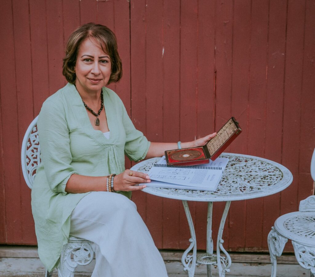 Meena is sitting on a chair with the bagua map